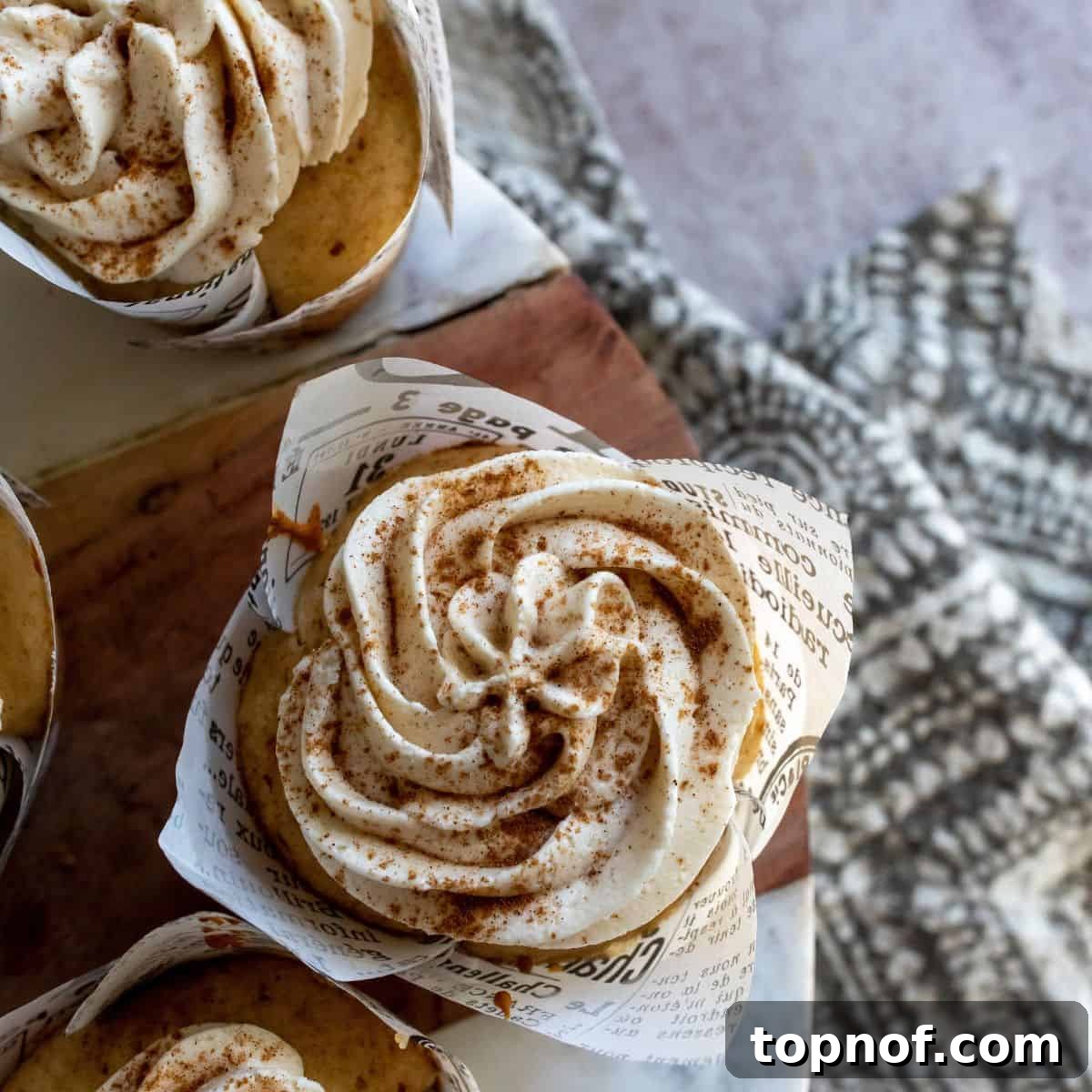 Delicious Apple Cider Cupcakes arranged closely on a rustic cutting board, showcasing their golden-brown tops and festive appeal.