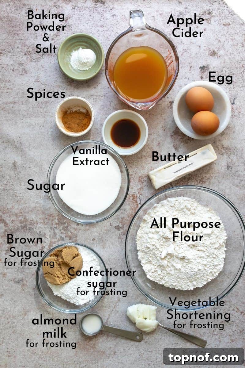 A collection of Apple Cider Cupcakes ingredients laid out on a kitchen counter in small bowls, including flour, sugar, spices, and liquid ingredients.