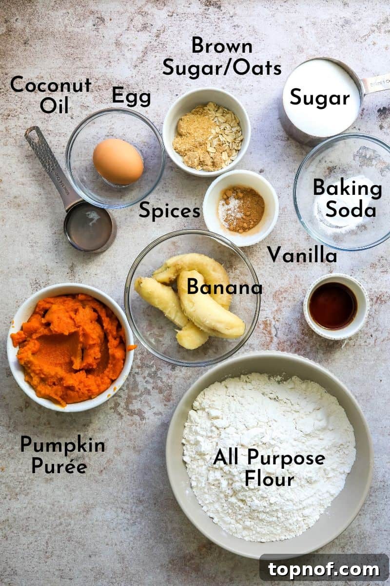Pumpkin Banana Bliss Muffins 3 Individual ingredients for Pumpkin Banana Muffins laid out on a counter in bowls, including bananas, pumpkin puree, flour, sugar, and spices.