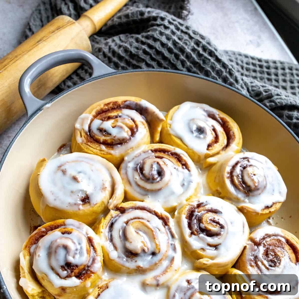 Warm Spiced Pumpkin Rolls 6 Baked pumpkin cinnamon rolls with golden brown tops, fresh out of the oven in a baking dish.