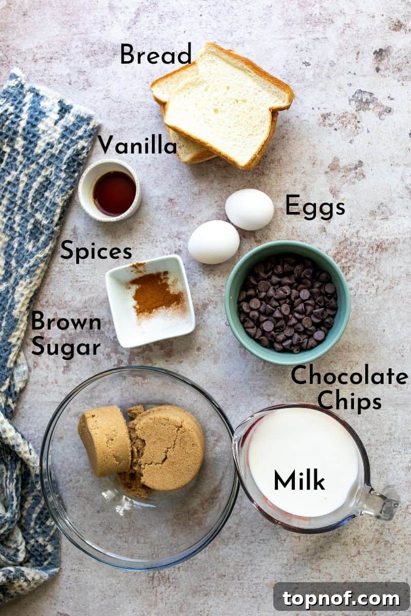 Irresistible Chocolate Chip Bread Pudding 3 A collection of Chocolate Chip Bread Pudding ingredients neatly arranged on a kitchen counter, showcasing fresh milk, eggs, sugar, spices, and chocolate chips.