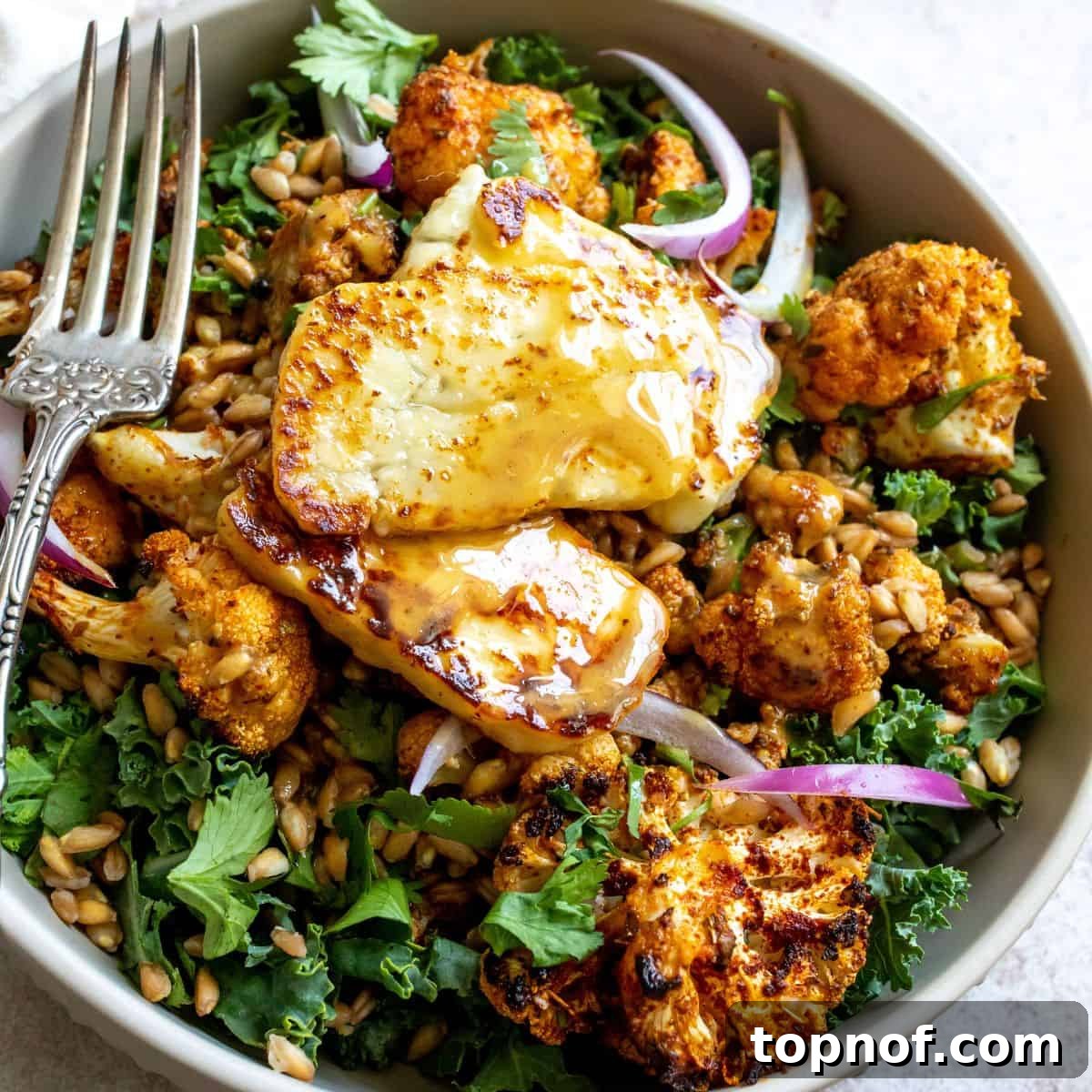 Delicious Farro Bowls with Maple Dijon Dressing Nutritious Farro Bowls with Fried Halloumi and Maple Dijon Dressing, served in a grey bowl.