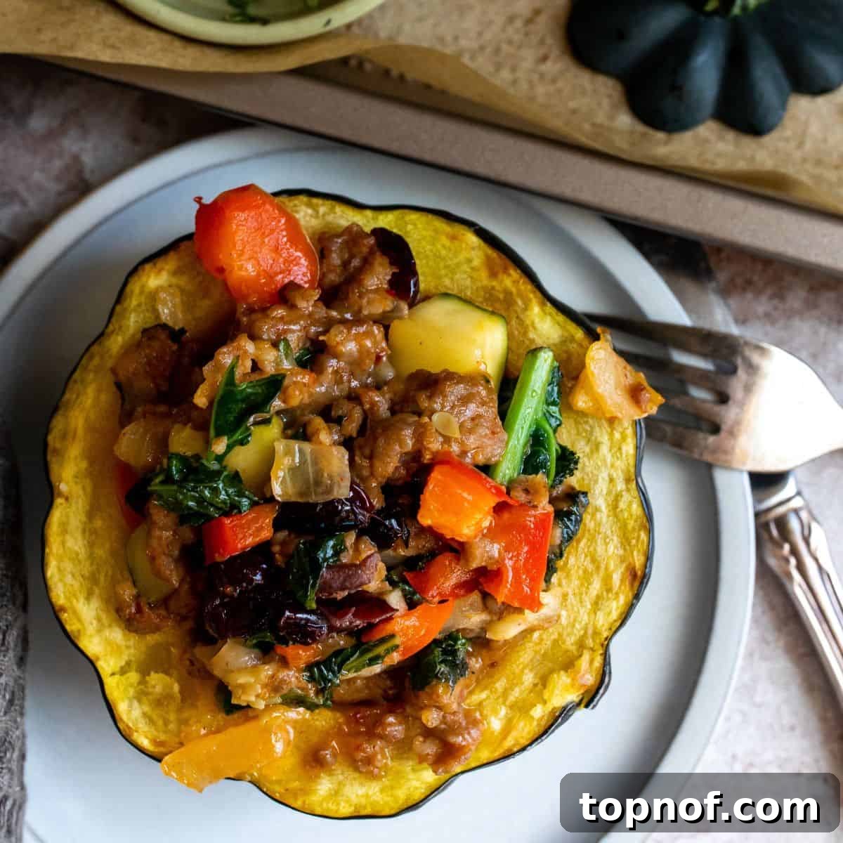 Hearty Sausage-Filled Acorn Squash 6 Beautifully presented sausage stuffed acorn squash on a white plate, garnished and ready to be enjoyed.