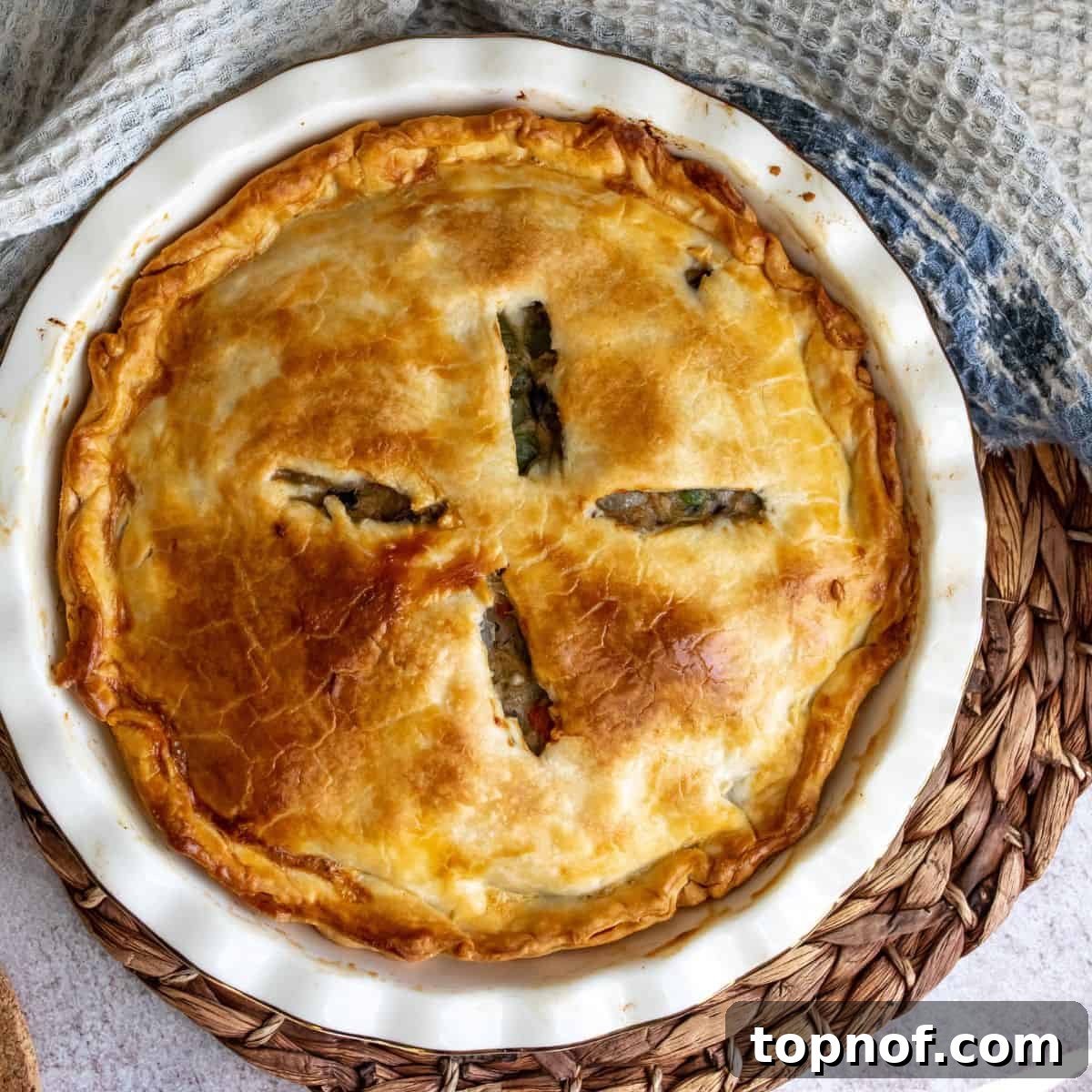 Healthy Chicken Pot Pie on a hot pad in a pie dish, just out of the oven.