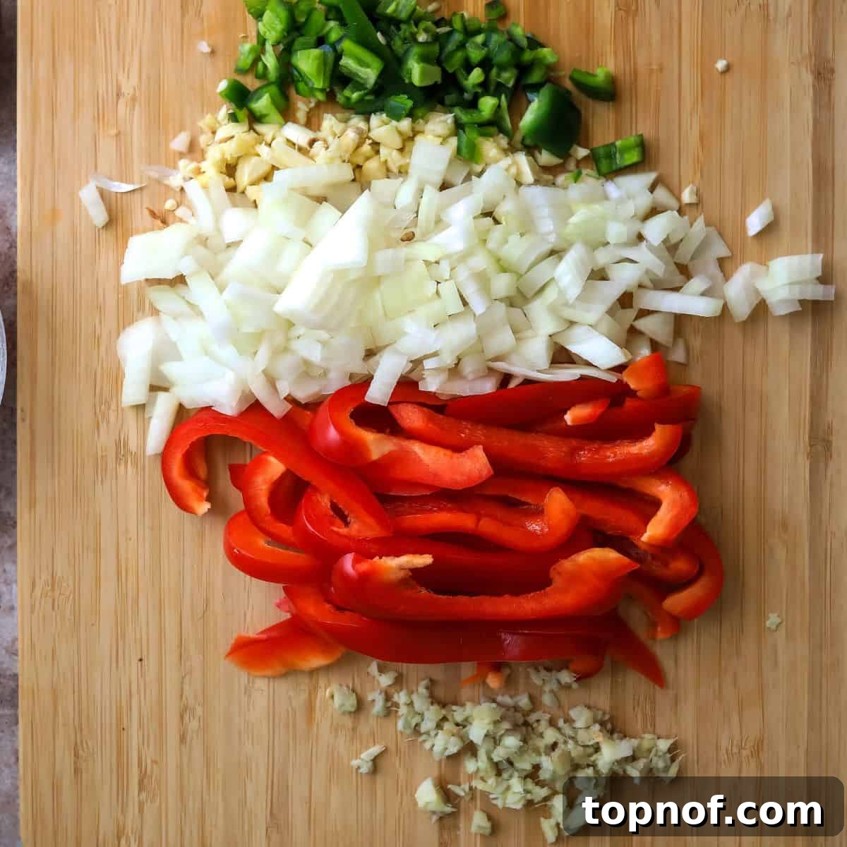 Velvety Coconut Shrimp Curry 4 Finely chopped vegetables including onions, jalapeños, red bell peppers, garlic, and ginger, meticulously prepped and ready for the initial sauté in the Coconut Shrimp Curry recipe.