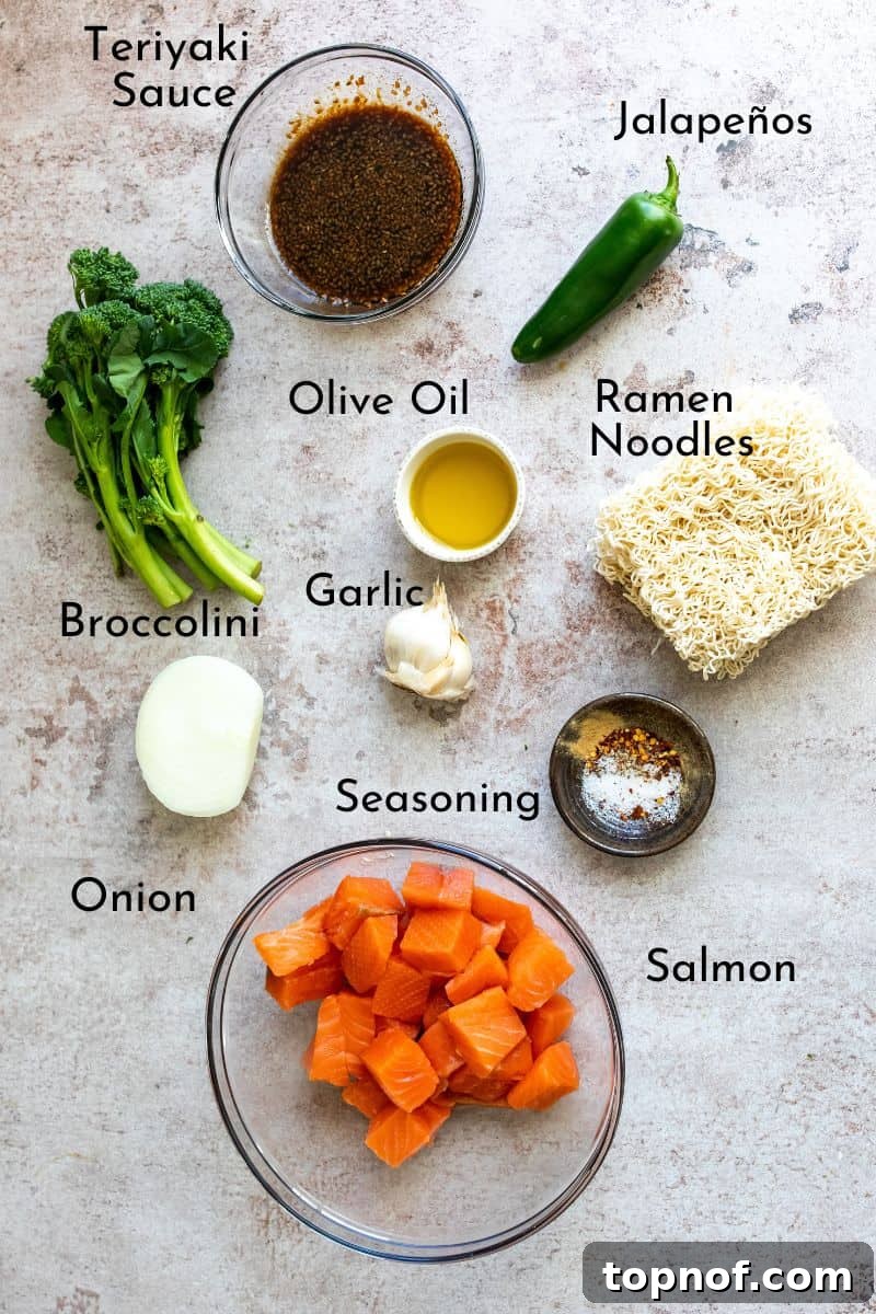 Savory Teriyaki Salmon Noodle Bowl 3 Fresh and vibrant ingredients for Teriyaki Salmon Noodles, including raw salmon, various seasonings, and chopped vegetables, neatly arranged in separate bowls on a grey kitchen counter.