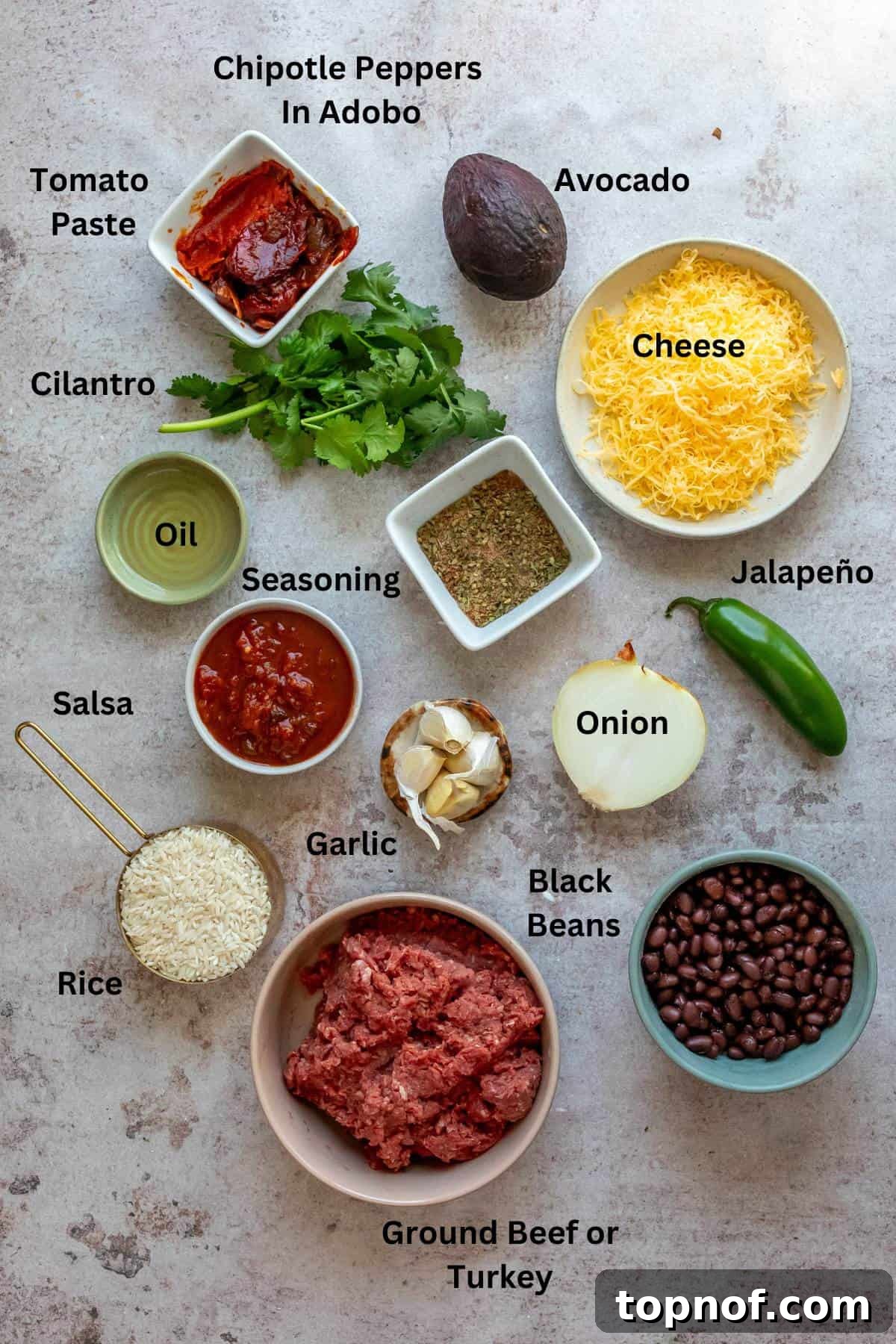 Loaded Taco Rice Bowl 3 Ingredients for Taco Rice Bowl laid out on a wooden cutting board, including ground meat, spices, onions, and chipotle peppers.