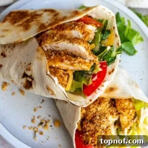 Crispy Chicken Delight 8 Crispy Chicken Wraps on a white plate with lettuce and tomato.