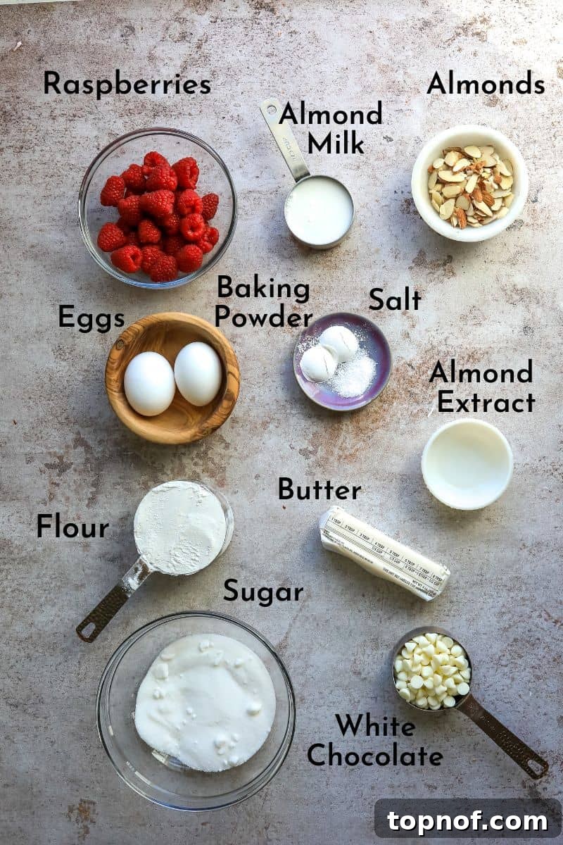 Luscious Raspberry White Chocolate Muffins 3 Carefully arranged ingredients for raspberry white chocolate muffins on a kitchen counter in small, neat bowls, showcasing freshness and quality.
