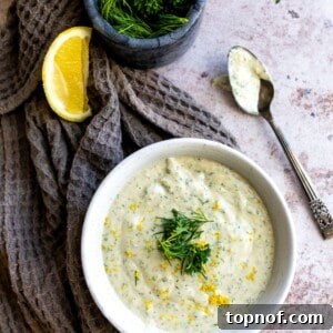 Vibrant Lemon Herb Tahini Sauce 7 Dressing in a white bowl with a spoon, highlighting its creamy texture.