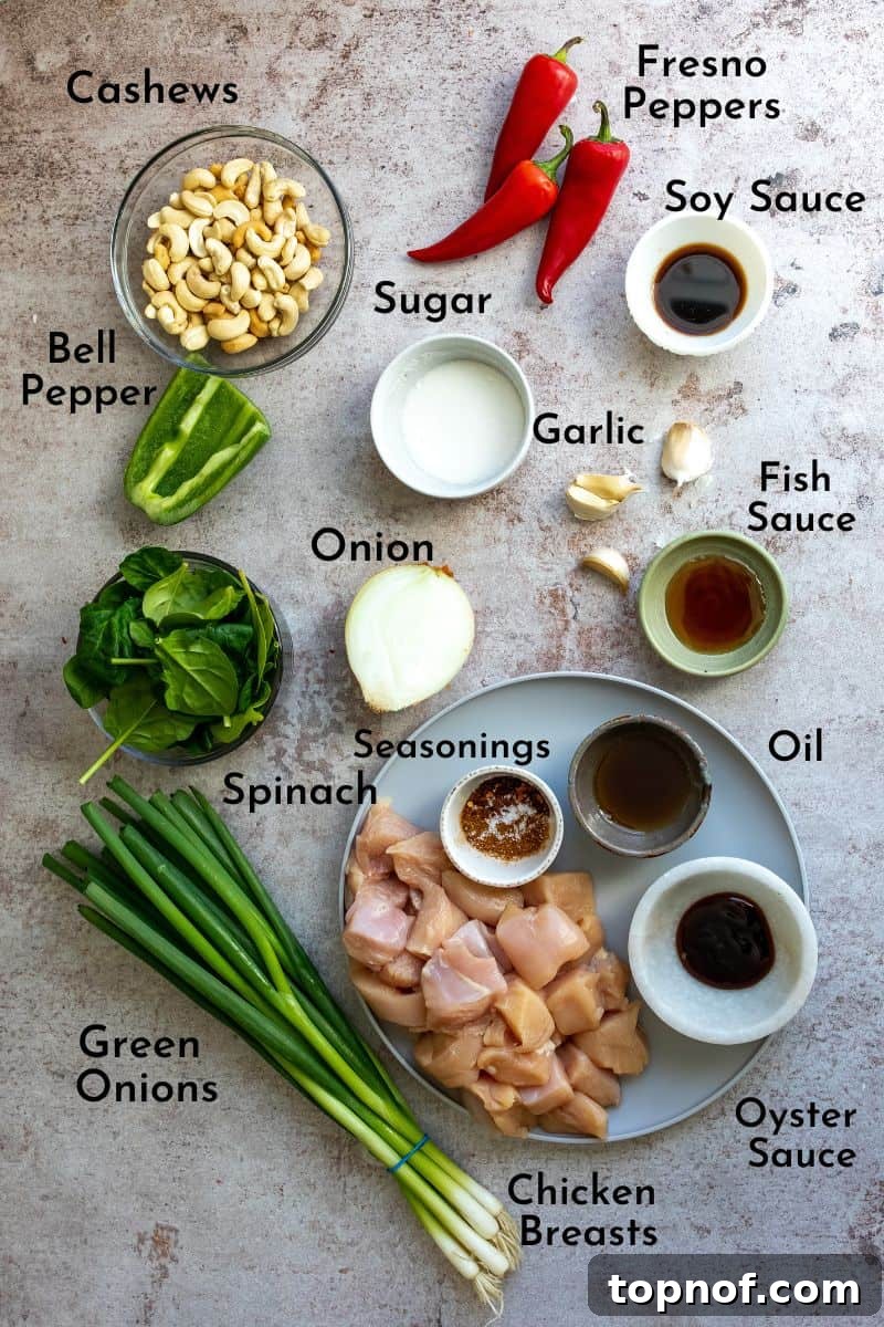 Classic Thai Cashew Chicken 3 A vibrant collection of fresh ingredients for Thai Cashew Chicken, including chopped chicken, bell peppers, onions, cashews, and various sauces, neatly arranged on a kitchen counter.