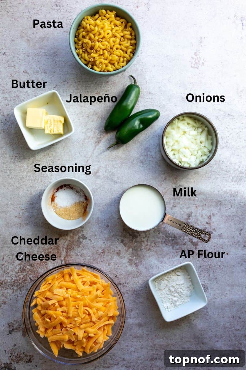 Fiery Mac & Cheese 3 All ingredients needed to make the recipe laid out on a gray counter in measuring cups and bowls.