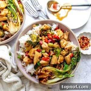 Teriyaki Chicken Rice Bowls on a counter with a plate and a spoon on the side.
