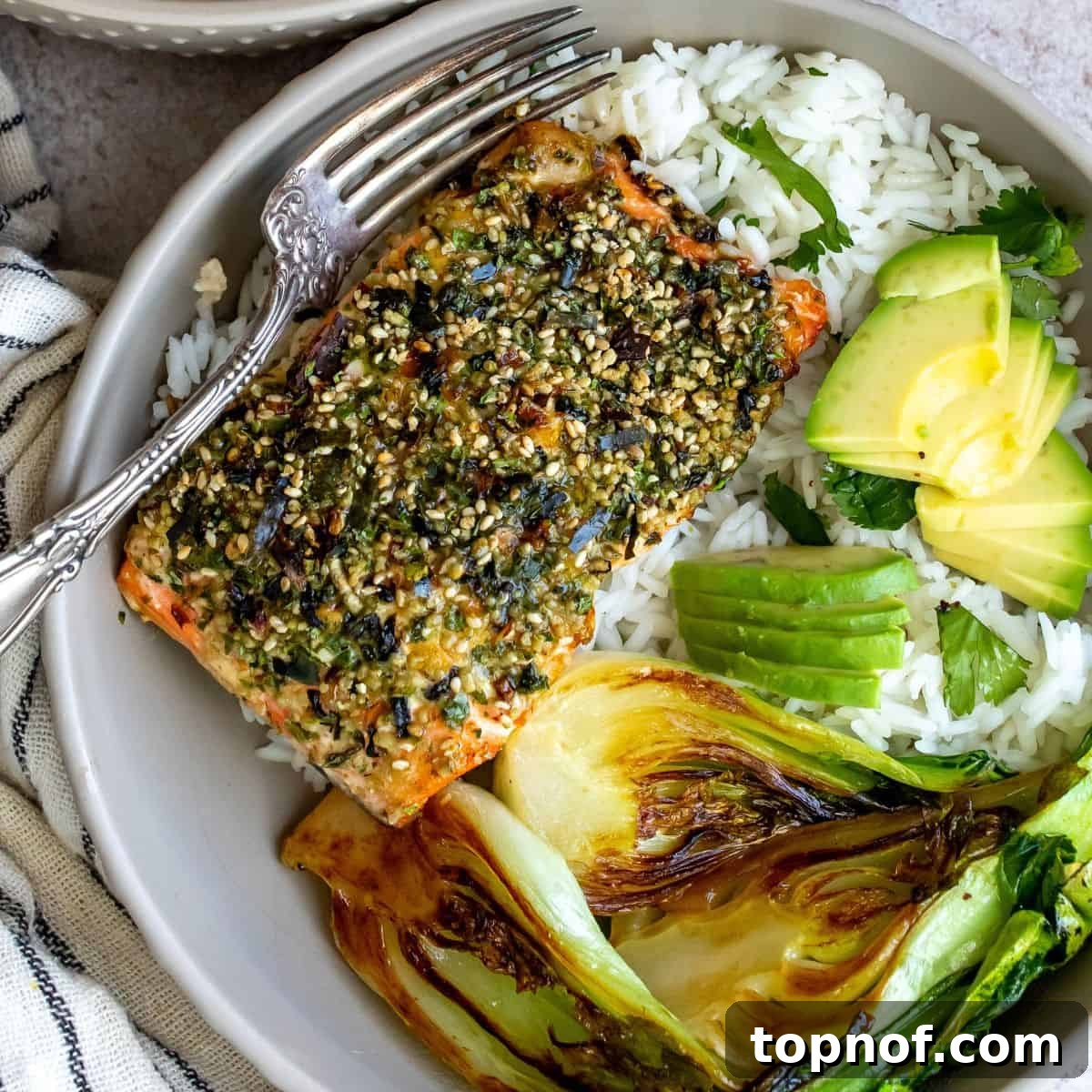 Savory Furikake Crusted Salmon 8 A beautifully plated bowl of Furikake Salmon and rice with a silver fork, ready for dining.