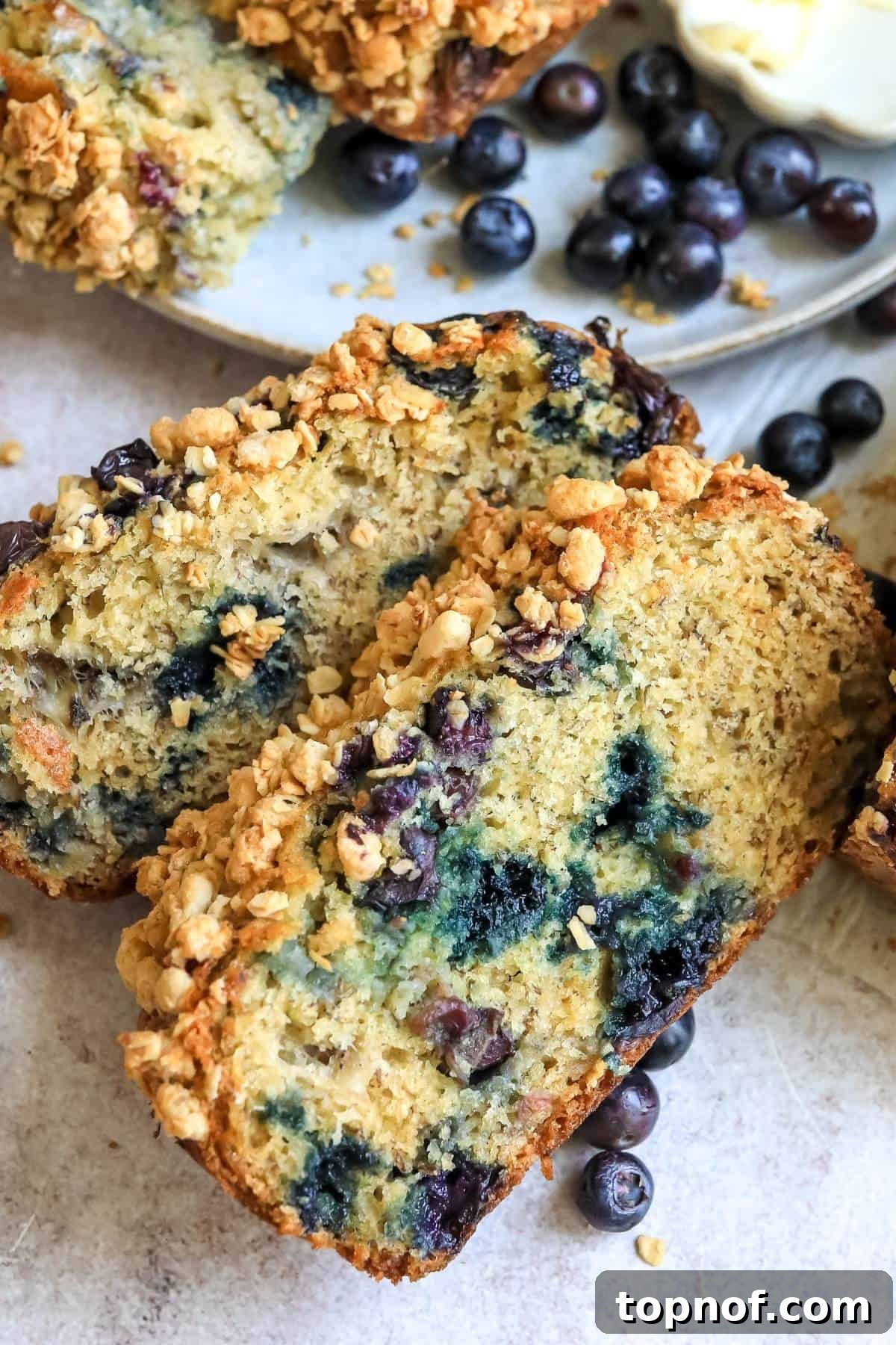Ultimate Blueberry Banana Nut Bread 5 A close-up shot of a slice of Blueberry Banana Nut Bread, revealing its moist texture, visible blueberries, and crunchy nuts, emphasizing its deliciousness.