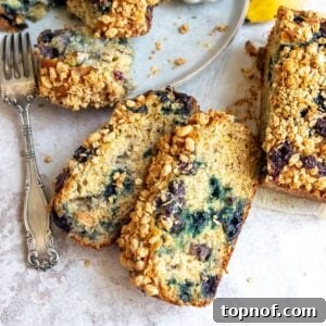 Banana Blueberry Nut Bread on a counter with a fork, ready to be served.