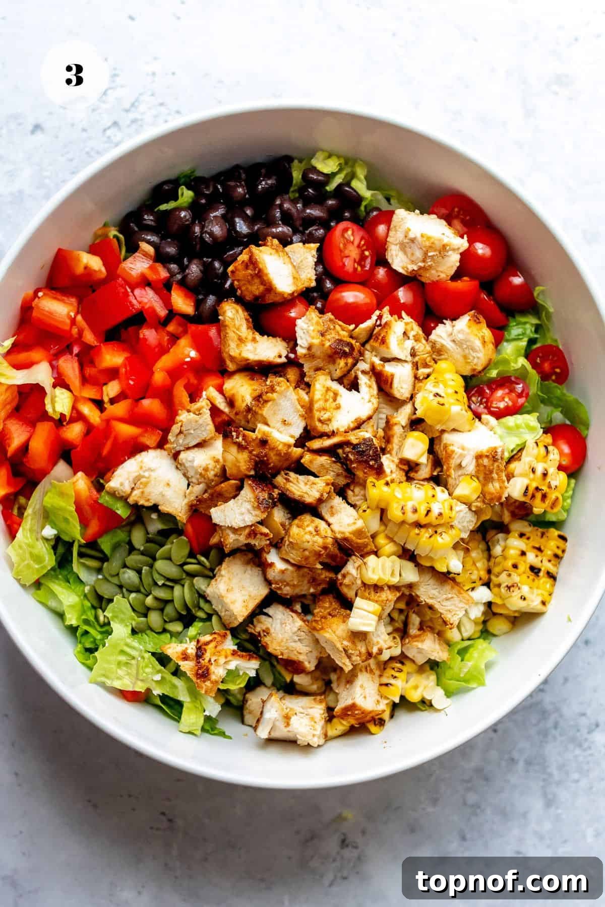 A large, inviting salad bowl brimming with all the colorful, fresh ingredients piled high, showcasing the abundance and vibrancy of the Southwest Salad.