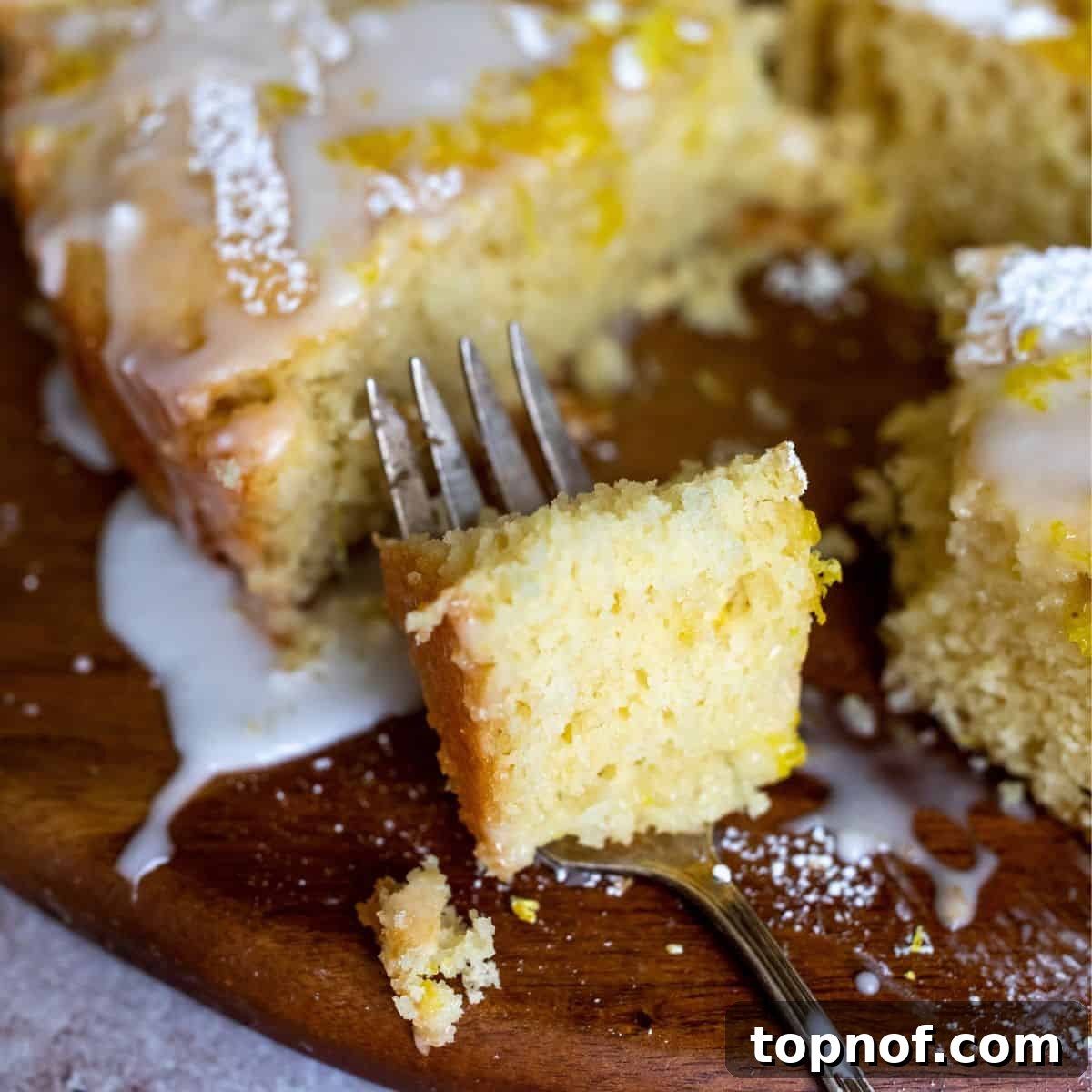 Amalfi Lemon Dream 5 A close-up of a slice of Italian lemon cake on a fork, highlighting its moist texture and light crumb.