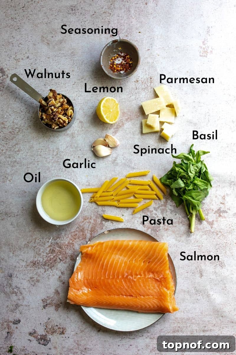 Zesty Salmon Pesto Pasta 3 A vibrant display of fresh ingredients for salmon pesto pasta, including fresh basil, spinach, walnuts, garlic, lemon, olive oil, and parmesan cheese arranged on small plates and bowls, ready for preparation.