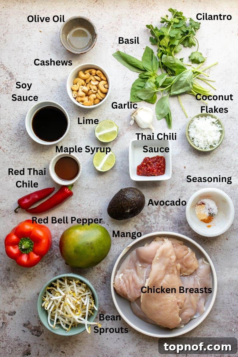 Assortment of fresh ingredients for Thai Mango Salad laid out on a kitchen counter, including chopped vegetables, herbs, and mango slices in small bowls.