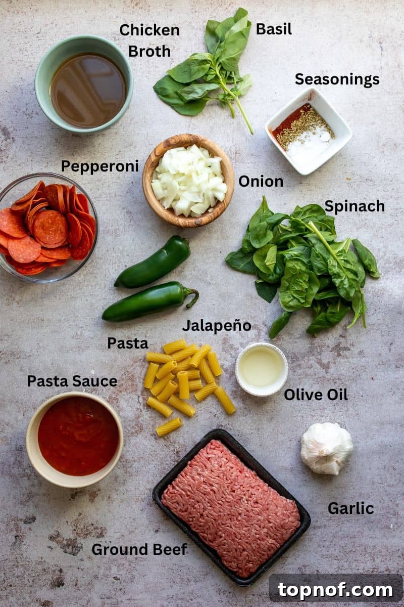 Various fresh ingredients for the pepperoni pasta recipe neatly arranged in small white bowls on a sleek grey kitchen counter, ready for preparation.