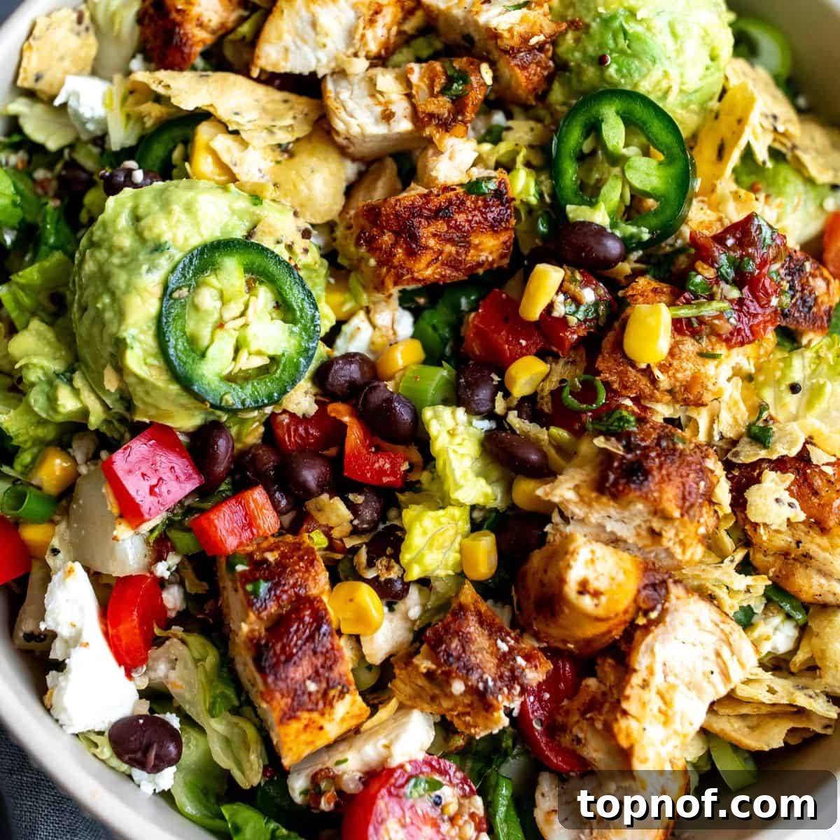 Santa Fe Fiesta Salad 7 A close-up shot of a white bowl filled with Santa Fe Salad, featuring juicy seasoned chicken and vibrant ingredients.