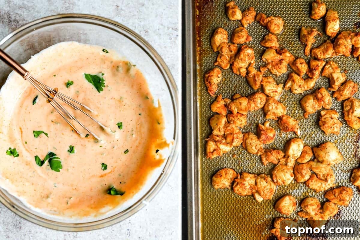 A big clear bowl of creamy sriracha Greek yogurt sauce next to a baking sheet filled with perfectly cooked, golden-brown spicy Cajun chicken pieces.