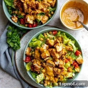 Two bowls with colorful Chicken Tikka Salad, showcasing the ingredients.