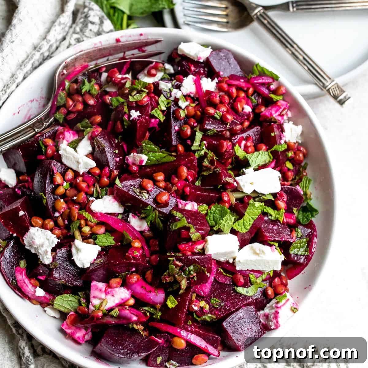 White bowl with beets and mint, an intimate close-up in a wooden bowl, highlighting textures.