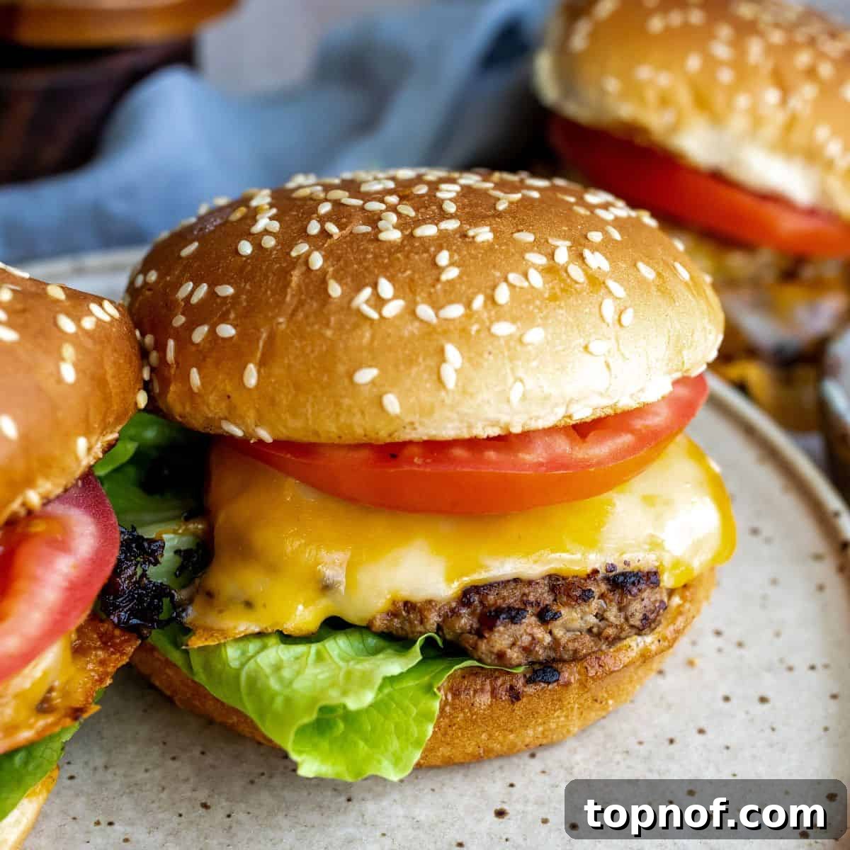 Signature Turkey Smash Burgers 2 Crispy Turkey Smash Burger on a sesame bun with fresh toppings, served on a plate.