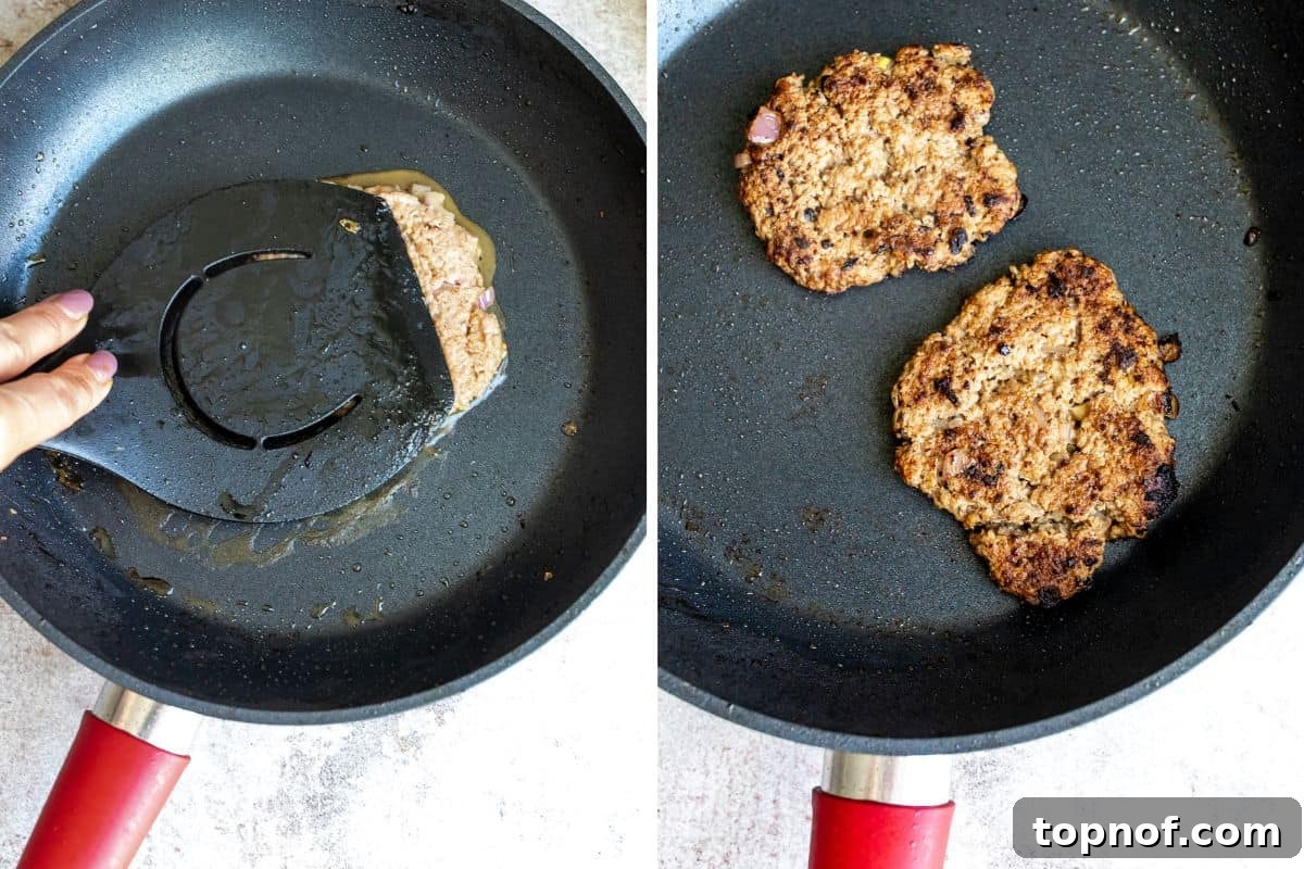 Signature Turkey Smash Burgers 5 Turkey smash burgers sizzling in a black frying pan, with a spatula pressing one down.
