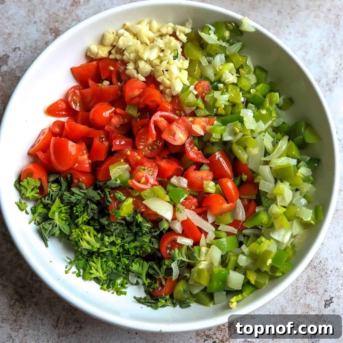 Sun-Kissed Tomato Condiment 5 Large white ceramic bowl with finely chopped roasted vegetables and fresh ingredients.