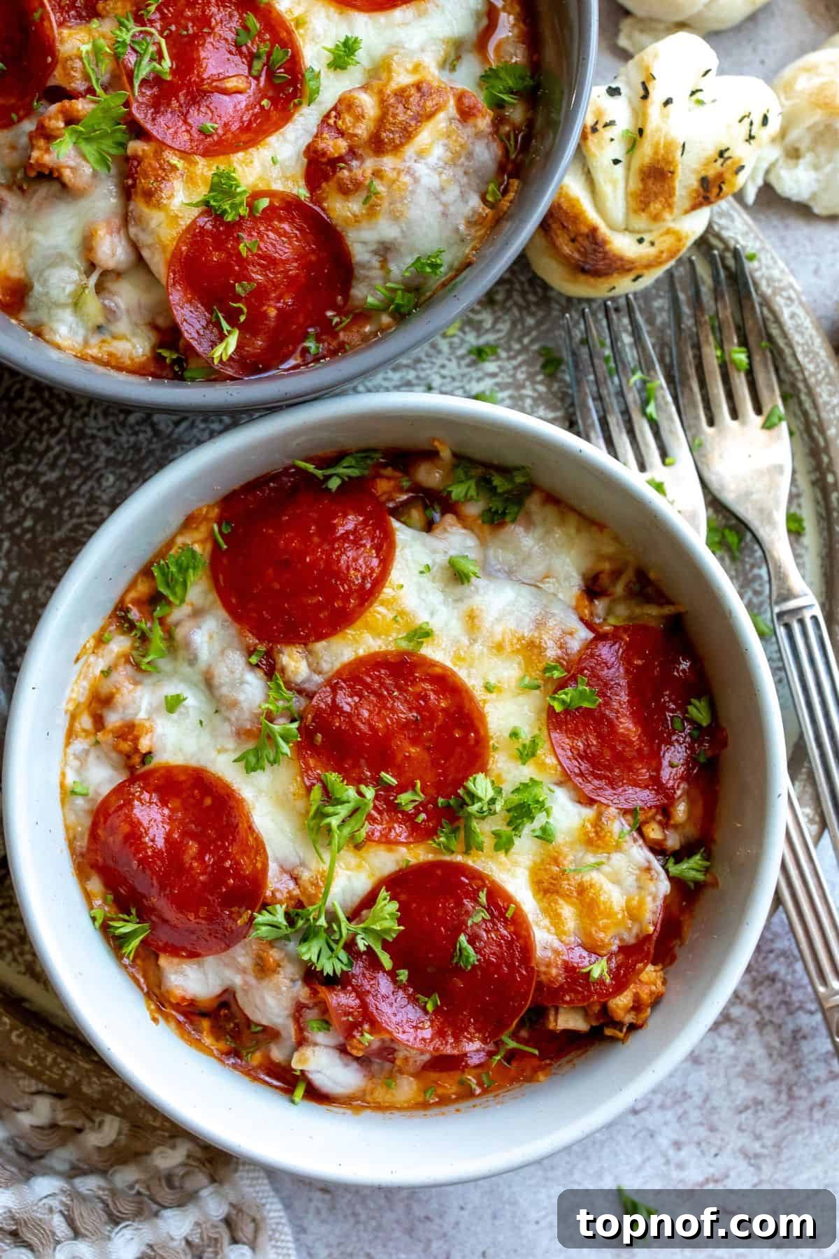 Pizza bowls in an oven safe ceramic bowl with pepperoni toppings and cheese.