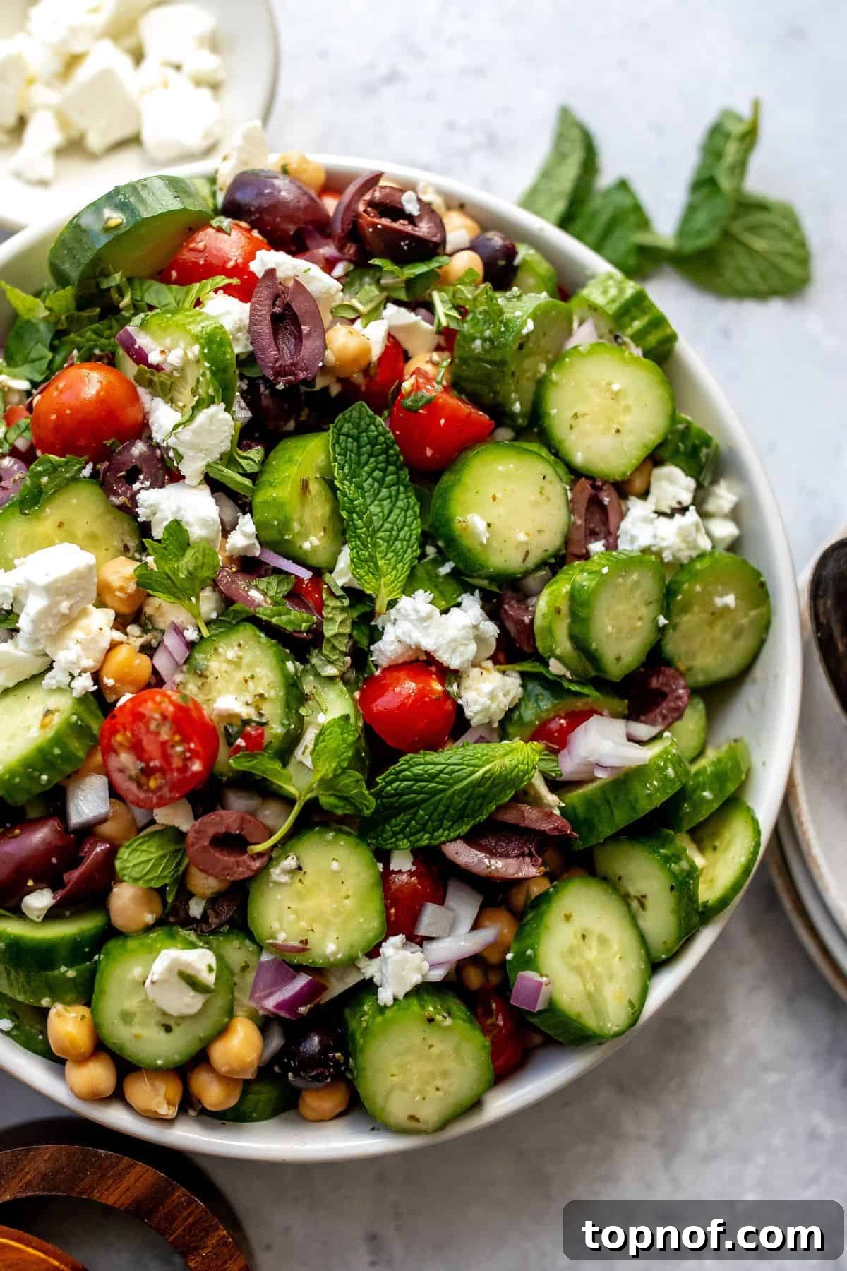Mediterranean Cucumber Delight 6 Mediterranean cucumber salad presented beautifully in a large white serving bowl, ready to be enjoyed.