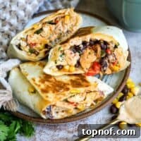 Plate with southwest chicken wraps and sauce on a spoon.