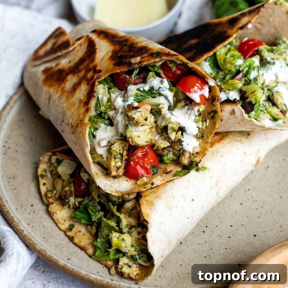 Vibrant Pesto Chicken Wraps 2 Freshly assembled Pesto Chicken Wraps on a rustic ceramic plate, garnished with crisp lettuce and juicy cherry tomatoes, perfect for a quick and healthy meal.