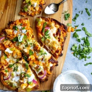 Buffalo chicken flatbread on a cutting board with ranch.