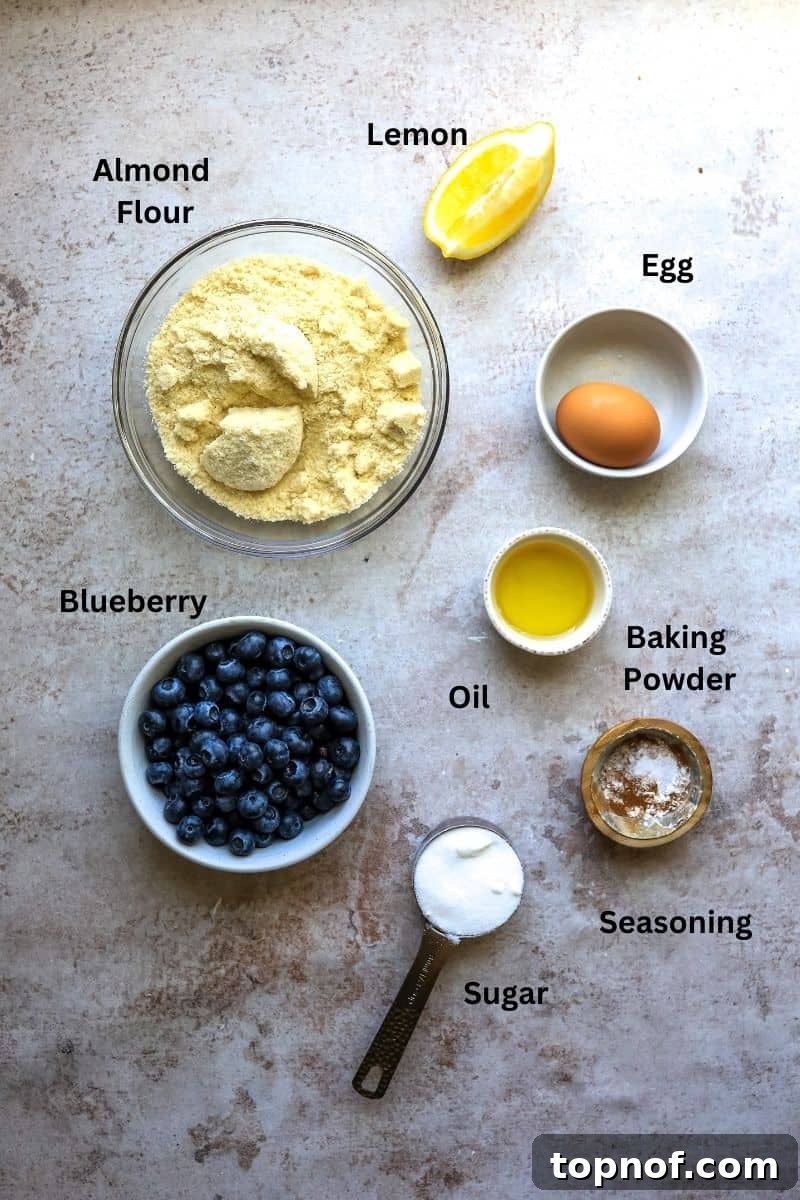 Luscious Gluten-Free Blueberry Cobbler 3 Collection of ingredients for gluten-free cobbler, including small bowls of flour, sugar, baking powder, and a lemon, with a carton of fresh blueberries.