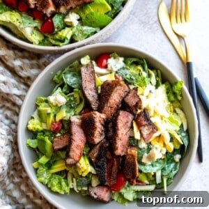 Bowl with a vibrant salad, perfectly cooked hard-boiled eggs, and expertly sliced blackened steak.