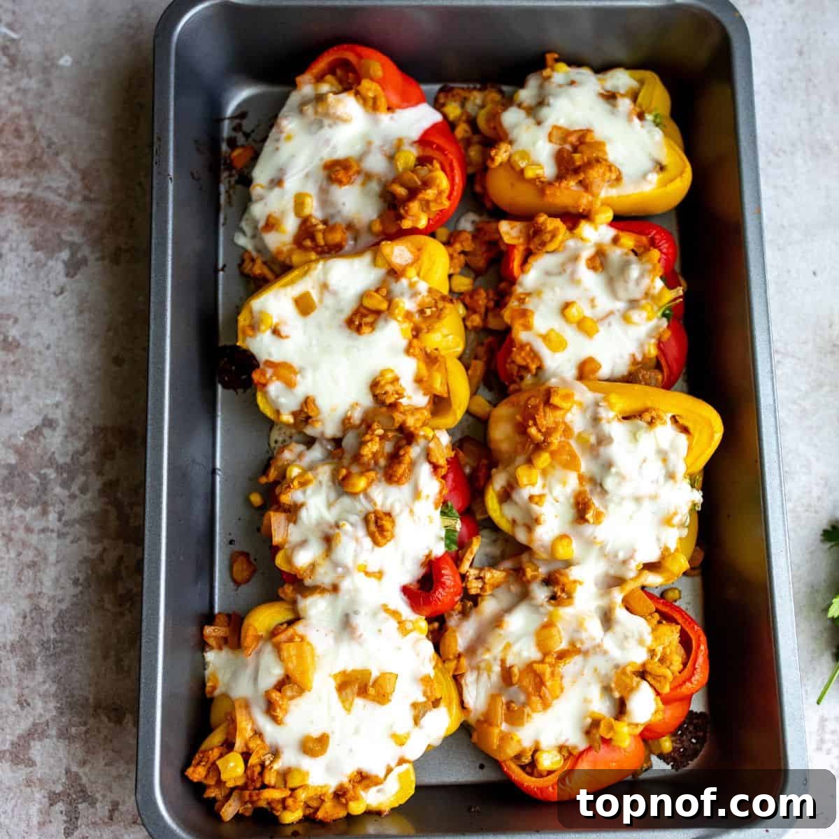 Flavorful Chicken Stuffed Bell Peppers 6 Baking sheet with ground chicken stuffed peppers, showing lots of melted cheese and golden edges.