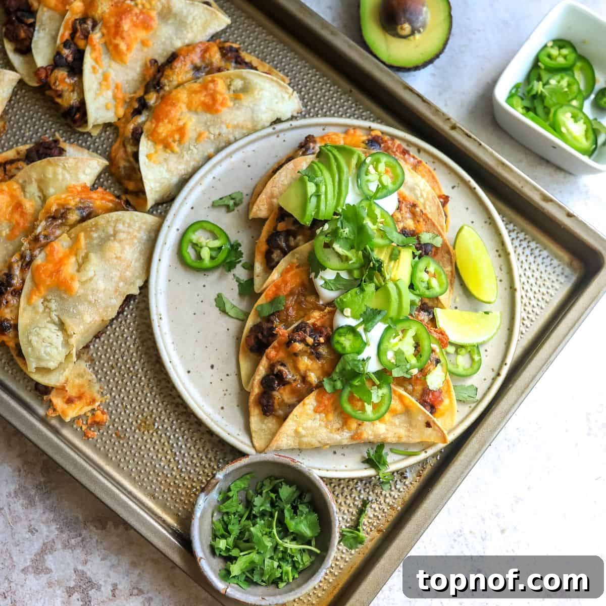 Golden-Crisp Black Bean Tacos 2 Crispy black bean tacos beautifully arranged on a white ceramic plate, surrounded by fresh toppings and lime wedges.