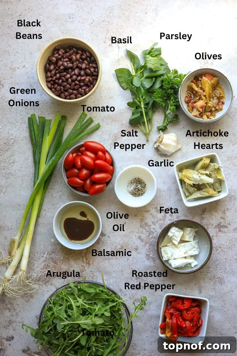 Zesty Mediterranean Black Bean Bowl 3 Ingredients needed to make Mediterranean Black Bean Salad on a counter including arugula, canned black beans, roasted red peppers, artichoke hearts, and fresh herbs.