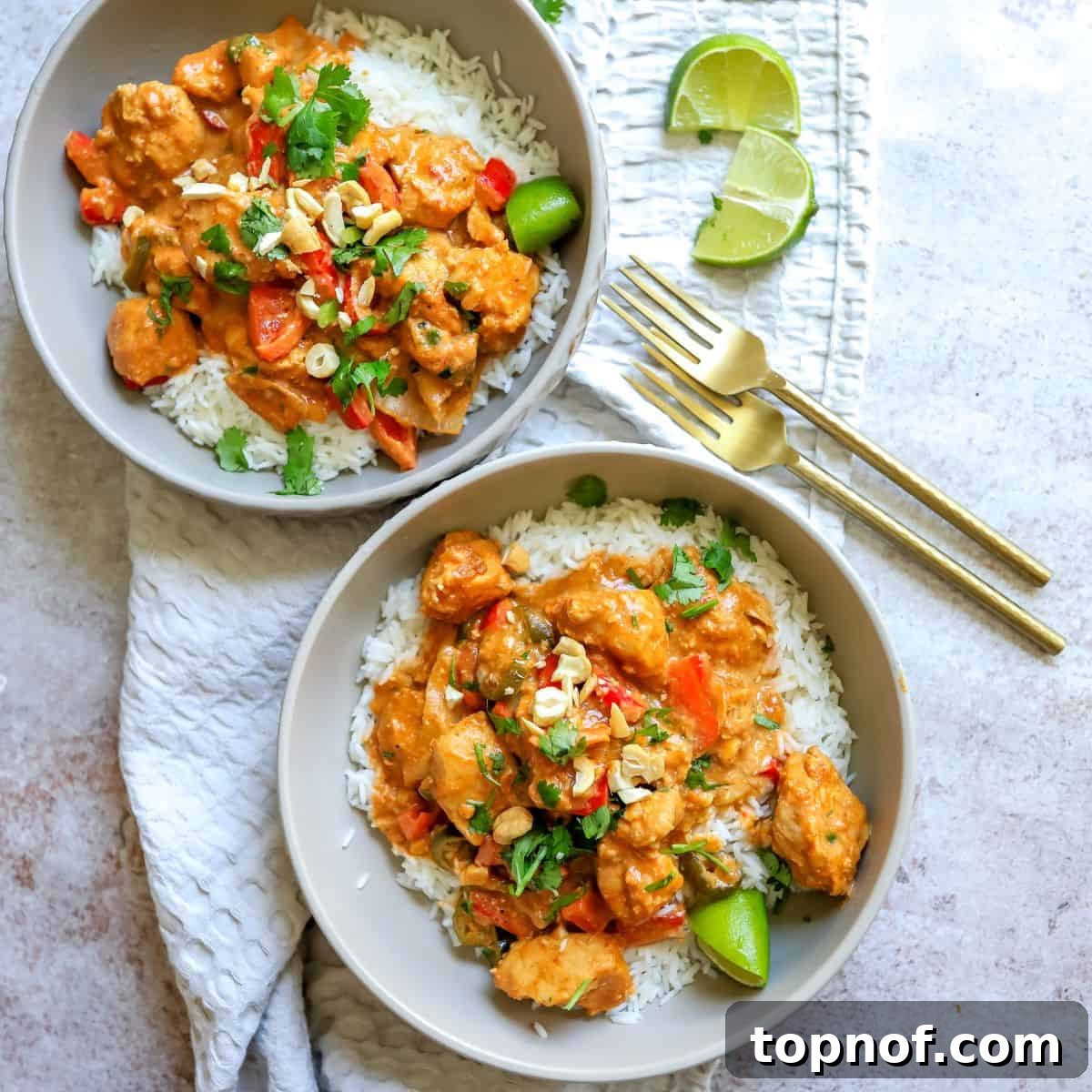 Creamy Slow Cooker Satay Chicken 2 Delicious slow cooker chicken satay served over white rice, garnished with fresh red peppers and limes, with elegant gold forks on the side.