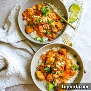Two bowls featuring white rice and succulent slow cooker chicken satay, garnished with fresh lime wedges.