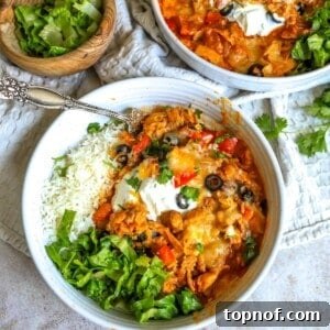 Melt-In-Your-Mouth Slow Cooker Chicken Enchiladas 8 White ceramic bowls with slow cooker chicken enchiladas and lettuce, a silver fork on the side.