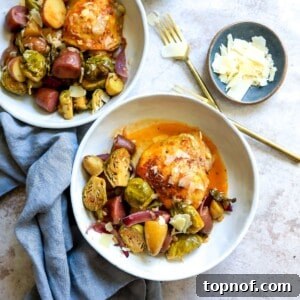 Two white ceramic bowls with chicken, veggies and potatoes in them.