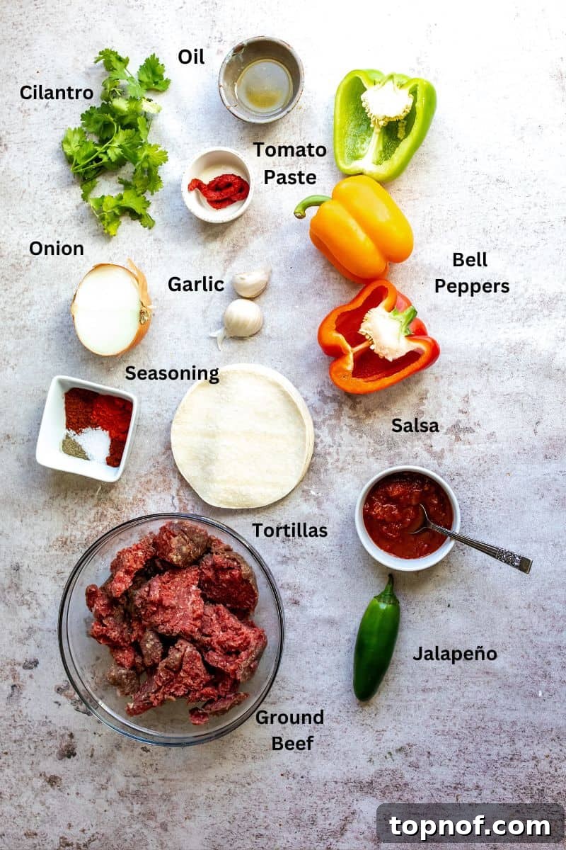 One-Pan Ground Beef Fajitas 3 Assortment of fresh ingredients for ground beef fajitas arranged on a kitchen counter: lean ground beef, colorful bell peppers, red onion, jalapeño, tomato paste, salsa, and various spices in small bowls.