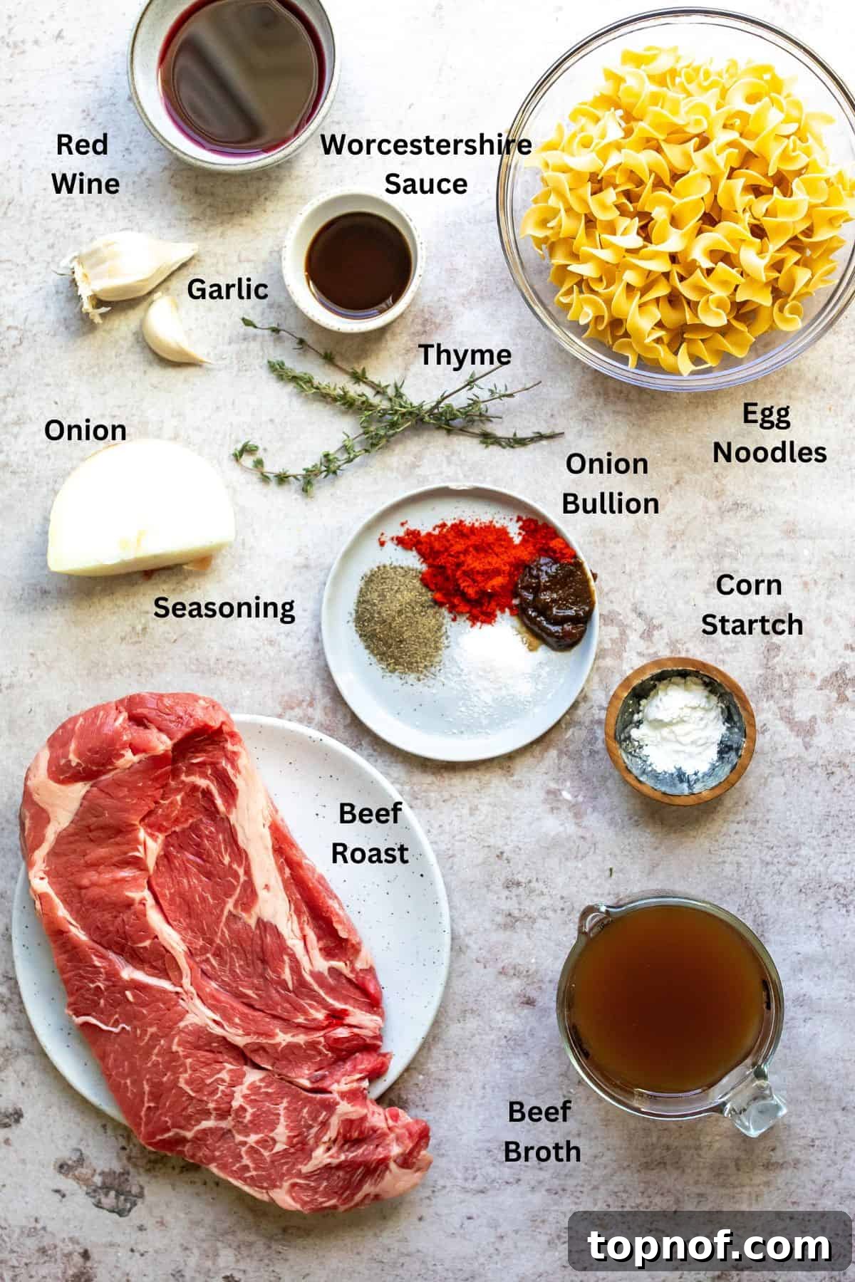 Variety of fresh ingredients for slow cooker beef and noodles, including beef roast, seasonings, broth, and vegetables, displayed in small bowls and plates.