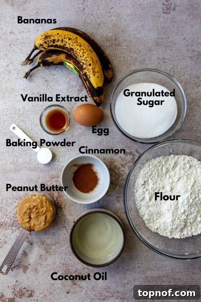 Peanut Butter Banana Dream Bread 3 Key ingredients laid out for making delicious peanut butter banana bread, including bananas, peanut butter, flour, and eggs.