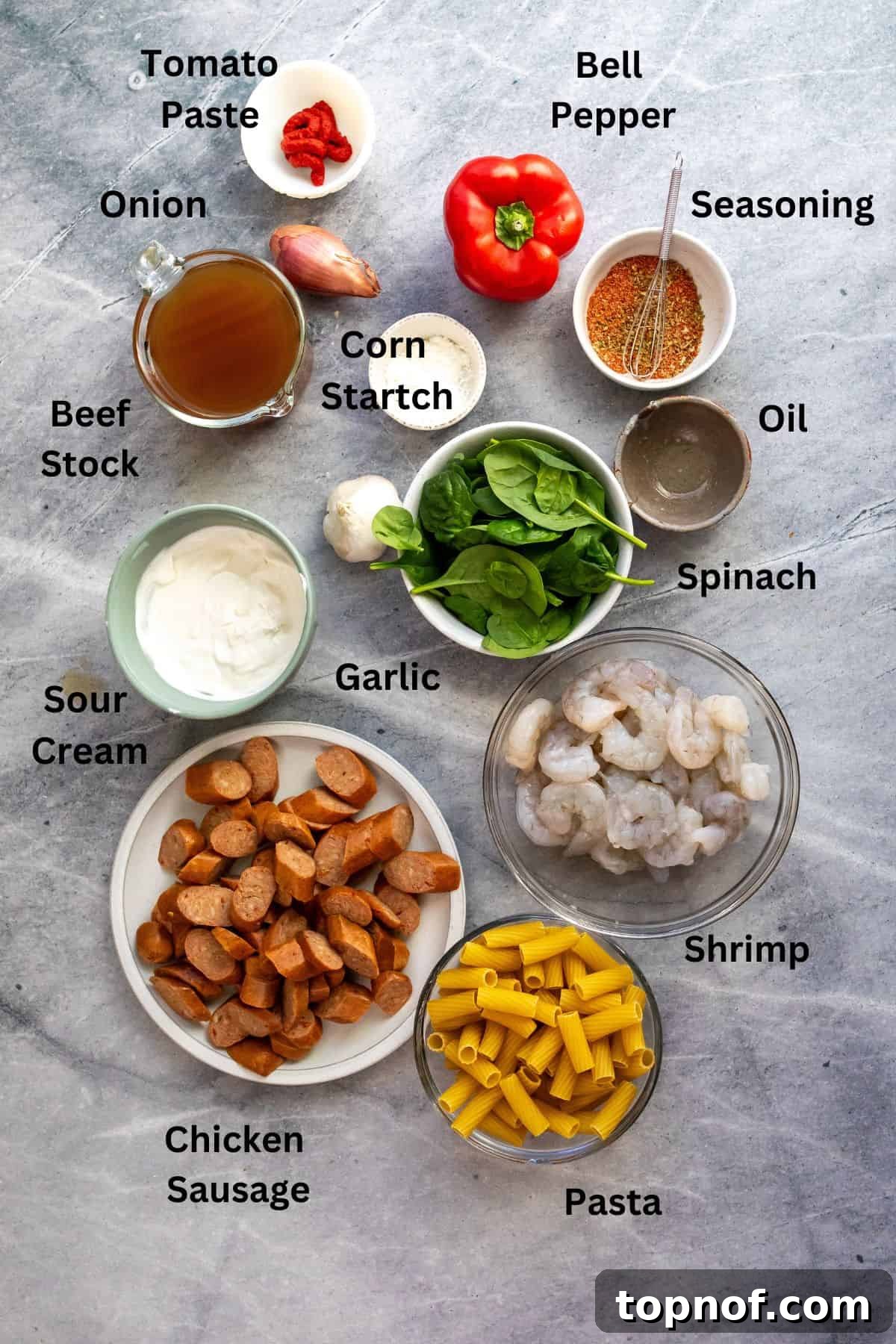 Cajun Kick Shrimp and Sausage Pasta 3 A thoughtfully arranged collection of fresh ingredients for Cajun shrimp and sausage pasta on a countertop, featuring vibrant bell peppers, raw shrimp, sliced sausage, and essential herbs and spices, ready for cooking.